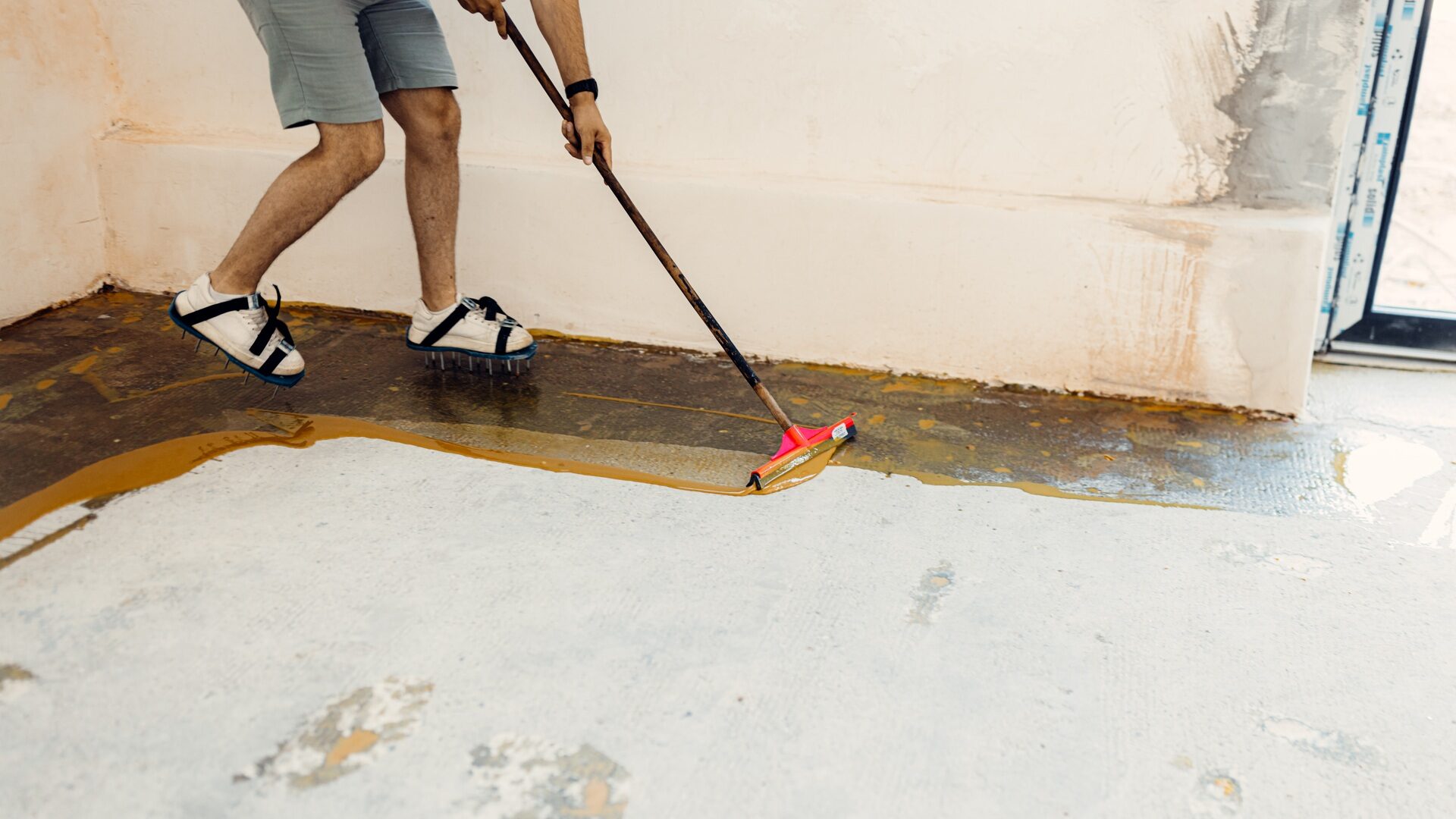 The worker applies yellow epoxy resin to the new floor