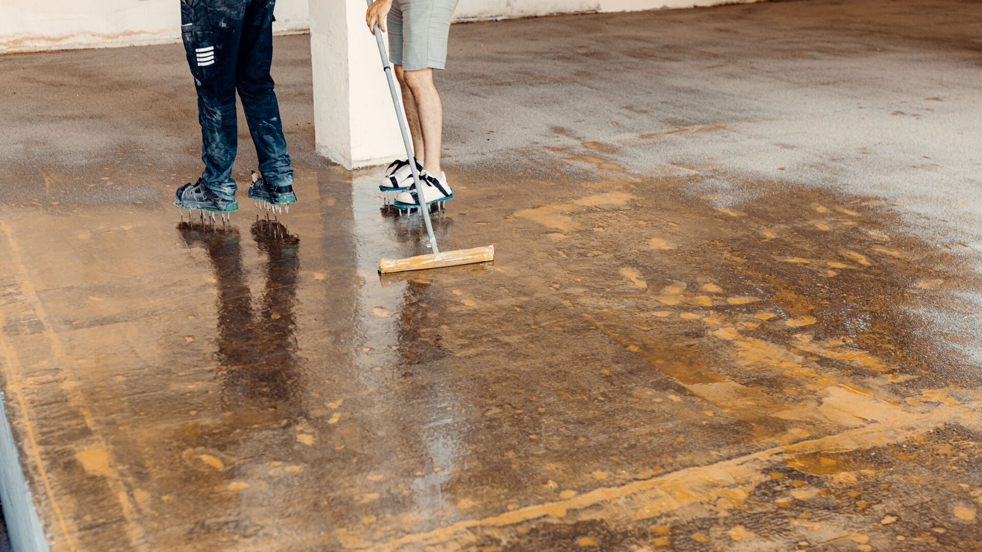 Worker applying floor primer with a special tool